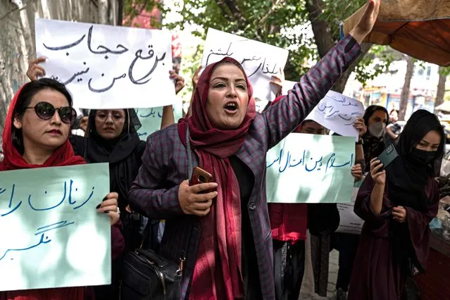 Members of Afghanistan's Powerful Women Movement, take part in a protest in Kabul on May 10, 2022. About a dozen women chanting “burqa is not my hijab” protested in the Afghan capital on May 10 against the Taliban's order for women to cover fully in public, including their faces. (Photo by Wakil Kohsar/AFP Photo)