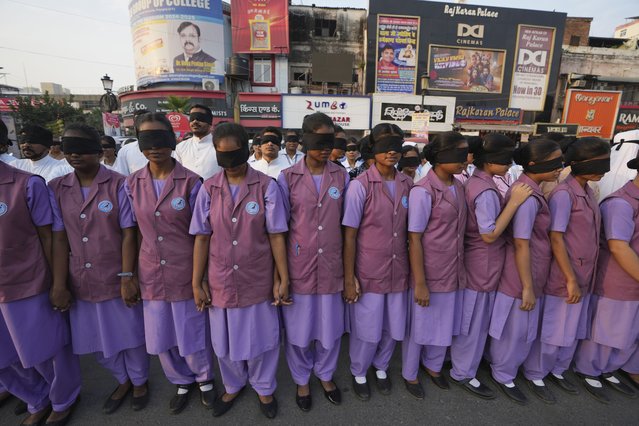 Indian nursing students wearing black ribbon over their eyes, walk with blind children during a rally on World Sight Day in Prayagraj, Uttar Pradesh, India, Thursday, October 10, 2024. (Photo by Rajesh Kumar Singh/AP Photo)