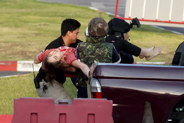 Armed commando soldiers carry a person out of Terminal 21 Korat mall in Nakhon Ratchasima, Thailand, Sunday, February 9, 2020. A gunman described as a soldier angry over a financial dispute killed a few people and then went on a far bloodier rampage Saturday in northeastern Thailand, shooting as he drove to the busy mall where shoppers fled in terror. Multiple people were killed in all, more people were injured. (Photo by Wason Wanichakorn/AP Photo)