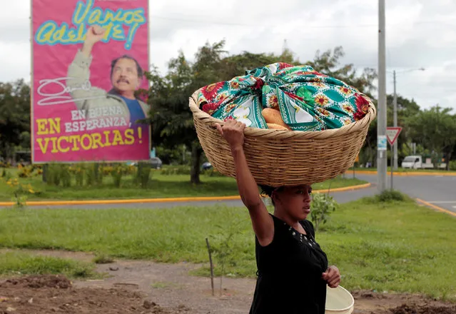 A girl sells bread as she walks past a billboard in support of Nicaragua's President Daniel Ortega in Catarina town, Nicaragua June 29, 2016. (Photo by Oswaldo Rivas/Reuters)