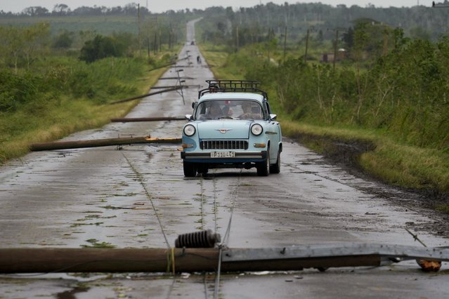 People drive along a road littered with fallen power lines after the passing of Hurricane Rafael in San Antonio de los Banos, Cuba, Thursday, November 7, 2024. (Photo by Ramon Espinosa/AP Photo)