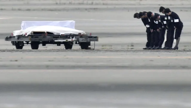 The coffins of the victims who were killed in the last weekend's attack on a restaurant in Bangladesh, arrive at Haneda Airport in Tokyo, Tuesday, July 5, 2016. The bodies of the Japanese victims arrived Tuesday morning in Tokyo on a Japanese government airplane. (Photo by Naohiko Hatta/Kyodo News via AP Photo)