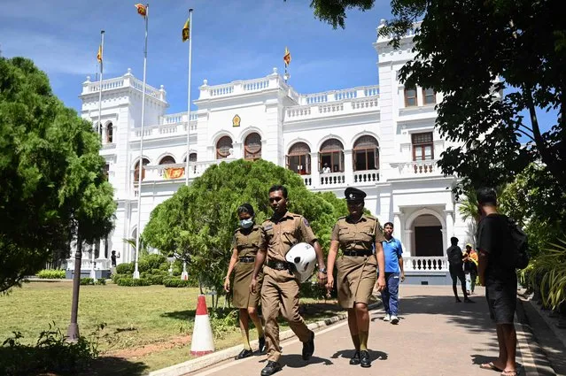 Police walk at the lawn of the office building of Sri Lanka's prime minister in Colombo on July 13, 2022, a day after thousands of anti-government protesters stormed into Sri Lanka Prime Minister Ranil Wickremesinghe's office after he was named acting president. (Photo by Arun Sankar/AFP Photo)