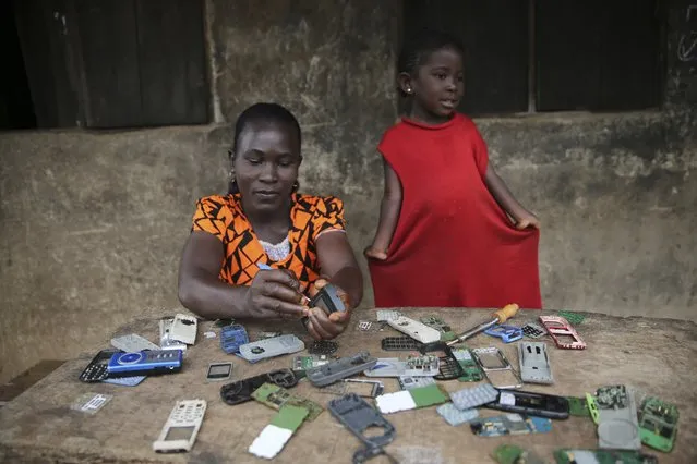 A woman repairs phones in front of a building during the Osun State governorship election at Ifofin village, Ilesa, southwest Nigeria August 9, 2014. (Photo by Akintunde Akinleye/Reuters)