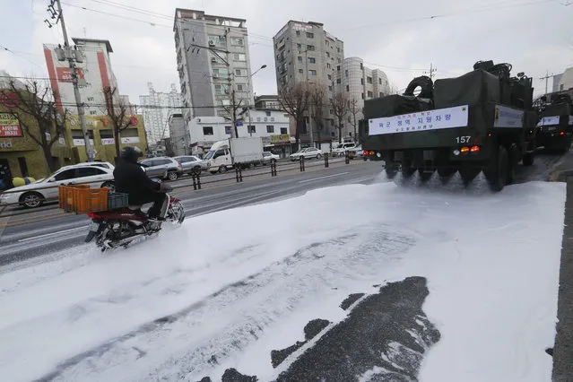 South Korean army trucks spray disinfectant as a precaution against the new coronavirus on a road in Seoul, South Korea, Wednesday, March 4, 2020. (Photo by Ahn Young-joon/AP Photo)