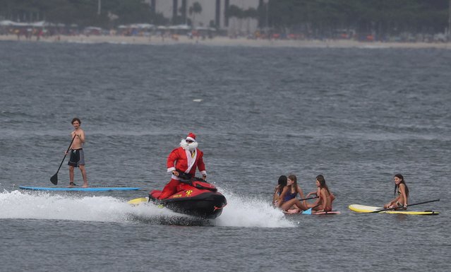 Firefighter Thiago Paiva, dressed as Santa Claus, rides on a jet ski during Christmas season celebrations in Copacabana beach in Rio de Janeiro, Brazil on December 17, 2024. (Photo by Pilar Olivares/Reuters)