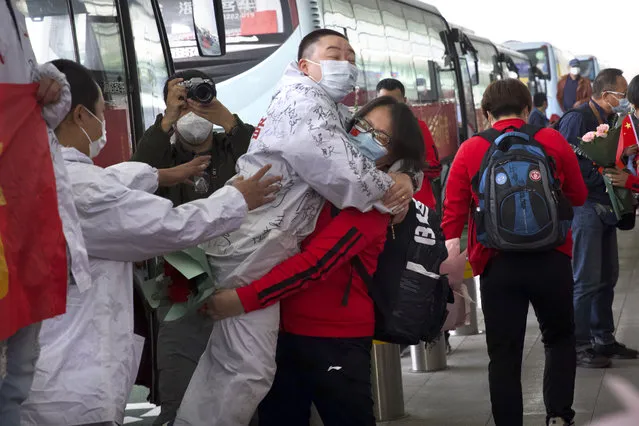 A medical worker from China's Jilin Province, in red, embraces a colleague from Wuhan as she prepares to return home at Wuhan Tianhe International Airport in Wuhan in central China's Hubei Province, Wednesday, April 8, 2020. Within hours of China lifting an 11-week lockdown on the central city of Wuhan early Wednesday, tens of thousands people had left the city by train and plane alone, according to local media reports. (Photo by Ng Han Guan/AP Photo)