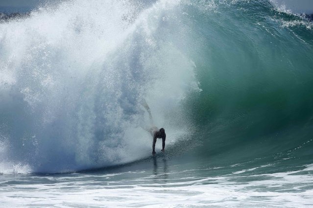 A swimmer catches a wave at “The Wedge” wave break in Newport Beach, California August 27, 2014. (Photo by Lucy Nicholson/Reuters)