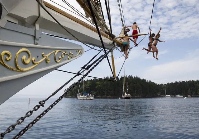 In this photo made Friday, August 3, 2012, Olivia Trankina of Marietta, Ga., and Liz Archibald of Clarks Summit, Penn., leap from the bowsprit of the schooner Mary Day in Bucks Harbor in South Brooksville, Maine. (Photo by Robert F. Bukaty/AP Photo)