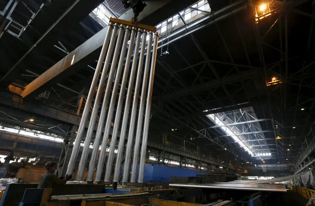 An employee works with cylindrical 6-metre aluminium ingots at the the Rusal Sayanogorsk aluminium smelter outside the town of Sayanogorsk, Russia, September 3, 2015. (Photo by Ilya Naymushin/Reuters)