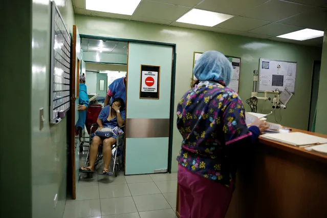 Medical personnel push Emileidy Ojeda, 26, in a wheelchair after a sterilization surgery in a hospital in Caracas, Venezuela July 27, 2016. (Photo by Carlos Garcia Rawlins/Reuters)