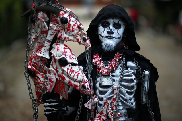 A reveller takes part in a parade known as “La Calabiuza” to celebrate the Day of the Dead in Tonacatepeque, El Salvador on November 4, 2023. (Photo by Jose Cabezas/Reuters)