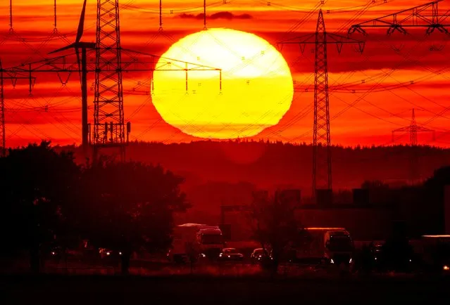 The sun rises above a highway in Frankfurt, Germany, Tuesday, August 2, 2022. (Photo by Michael Probst/AP Photo)