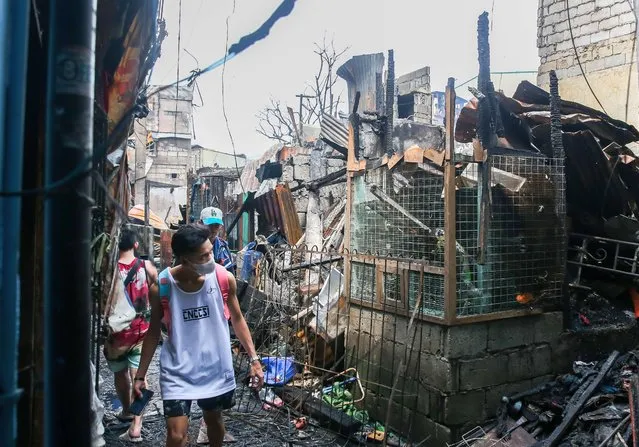 Residents search for belongings from their charred homes after a slum area fire in Quezon City, the Philippines, September 9, 2022. (Photo by Rouelle Umali/Xinhua News Agency)