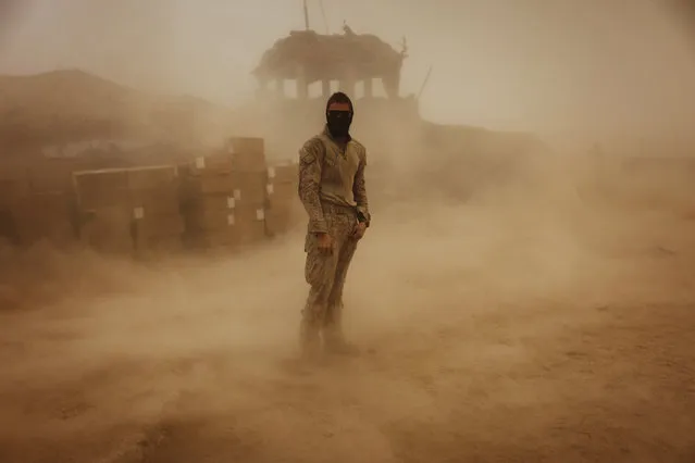 Private First Class Brandon Voris, 19, of Lebanon, Ohio, from the First Battalion Eighth Marines Alpha Company stands in the middle of his camp as a sandstorm hits his remote outpost near Kunjak in southern Afghanistan's Helmand province, October 28, 2010. (Photo by Finbarr O'Reilly/Reuters)
