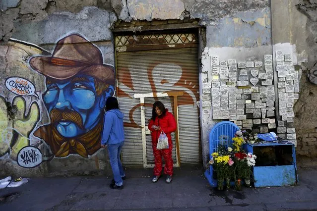 Women stand beside a street as demonstrators attend a march marking the anniversary of the start of the country's 1973 military coup, in Santiago, Chile September 13, 2015. (Photo by Ivan Alvarado/Reuters)