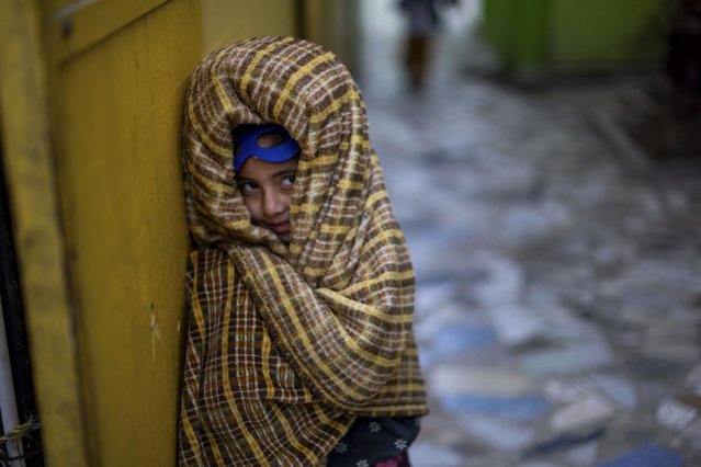 A child wrapped in a blanket walks through the Agape Mundial shelter Saturday, January 25, 2025, in Tijuana, Mexico. (Photo by Ethan Swope/AP Photo)