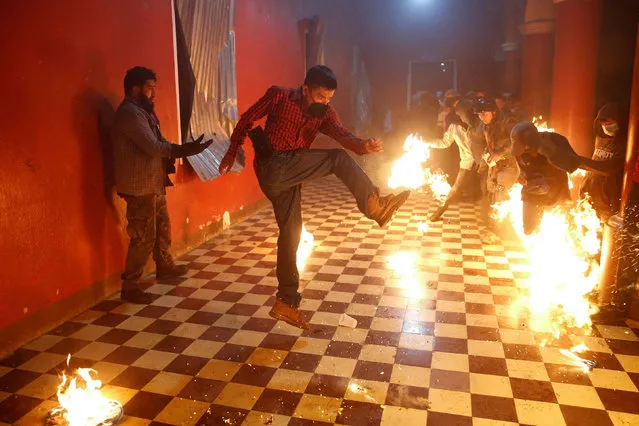People kick flaming balls at each other during the “Flaming balls” festival as part of the yearly commemoration of the Immaculate Conception of the Virgin Mary, at the central plaza in San Cristobal Verapaz, Guatemala on December 8, 2021. (Photo by Luis Echeverria/Reuters)