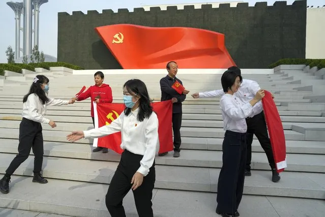 Visitors to the Museum of the Communist Party of China holds party flags to pose for photos in Beijing, Wednesday, October 12, 2022. For decades Chinese journalist Ho Pin has successfully predicted rising newcomers in the Chinese Communist Party, and says that leader Xi Jinping is so powerful, there is little point in predicting the leadership line up to be announced at the Communist Party congress that begins Sunday. (Photo by Ng Han Guan/AP Photo)
