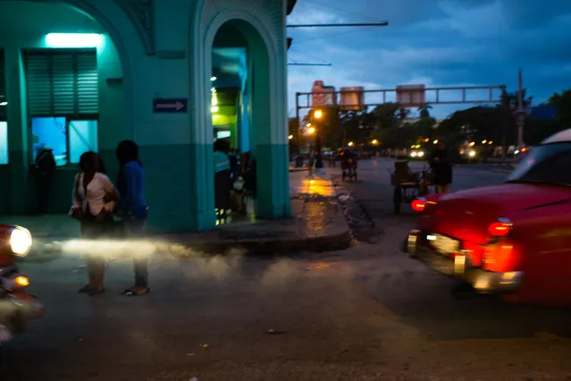 As the sun rises over Old Havana on January 31, 2015, cars drive by polluting the air as pedestrians make their way to work. (Photo by Sarah L. Voisin/The Washington Post)