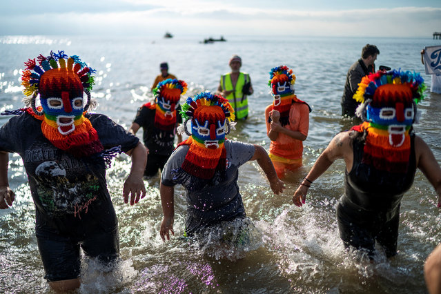 People run into the Atlantic Ocean during the annual Coney Island Polar Bear Club New Year's Day plunge in Brooklyn, New York, U.S., January 1, 2024. (Photo by Eduardo Munoz/Reuters)