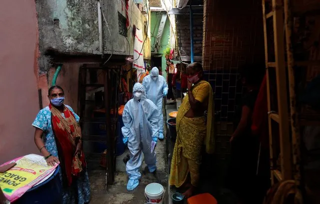 Health workers walk in a lane during a free medical camp in Dharavi, one of Asia's largest slums in Mumbai, India, Saturday, June 20, 2020. India is the fourth hardest-hit country by the COVID-19 pandemic in the world after the U.S., Russia and Brazil. (Photo by Rafiq Maqbool/AP Photo)