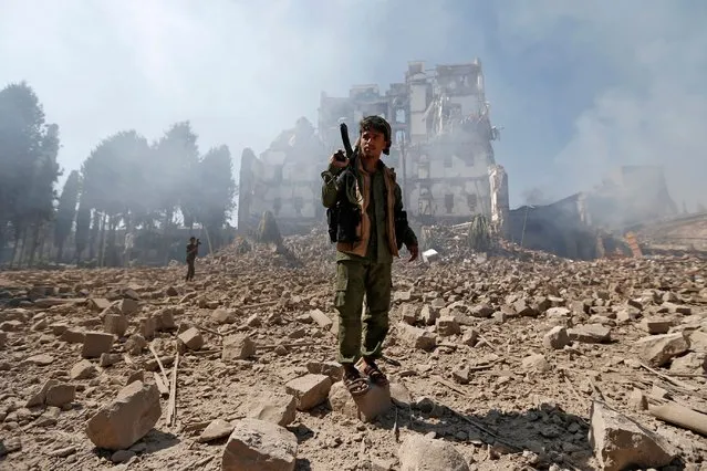 Huthi rebel fighters inspect the damage after a reported air strike carried out by the Saudi-led coalition targeted the presidential palace in the Yemeni capital Sanaa on December 5, 2017. Saudi-led warplanes pounded the rebel-held capital before dawn after the rebels killed former president Ali Abdullah Saleh as he fled the city following the collapse of their uneasy alliance, residents said. (Photo by AFP Photo/Stringer)