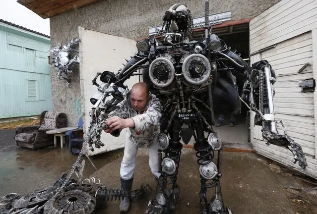 Mechanic and welder Sergei Kulagin, 32, tests the “Alien Samurai”, an electro-mechanical mobile robot made by Kulagin using car components, outside an automobile repair workshop in the town of Divnogorsk outside Krasnoyarsk, Siberia, October 15, 2014. (Photo by Ilya Naymushin/Reuters)