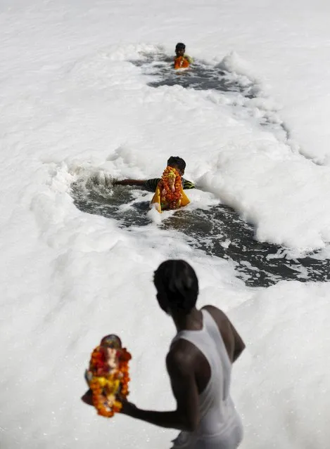 Devotees carry statues of the Hindu god Ganesh, the deity of prosperity, to be immersed into the polluted waters of the river Yamuna on the last day of the Ganesh Chaturthi festival, in New Delhi, India, September 27, 2015. (Photo by Adnan Abidi/Reuters)