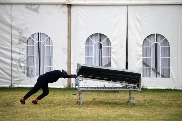 A support staff member pushes newly arrived beds and mattresses at the Kenyatta stadium where screening booths and an isolation field hospital are installed to aid with COVID-19 (novel coronavirus) patients in Machakos, on July 28, 2020. The Kenyan president on July 27, 2020, banned the sale of alcohol in restaurants after noting an “aggressive surge” in COVID-19 cases among young people who were socialising “particularly in environments serving alcohol”. (Photo by Simon Maina/AFP Photo)