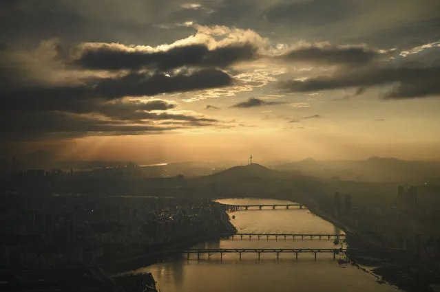A general view shows the Seoul city skyline during sunset from the top of the Lotte World Tower on August 7, 2020. A Lotte promotional event entitled “Summerest 2020” is offering shoppers who spend over 100,000 won (80 US dollars) at Lotte World Mall the chance to apply to spend the night at a height of 555-metres atop the Lotte Tower, which with 123 floors, is Seoul's tallest building. (Photo by Ed Jones/AFP Photo)