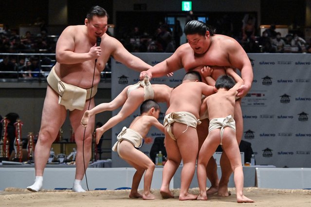 Retired Mongolian-born “yokozuna” wrestler Hakuho (L), who now goes by the name Miyagino, watches as participants try to push out Japanese wrestler Hakuoho (R) during a sumo class for youngsters on the sidelines of the 14th Hakuho Cup, a competition for young sumo wrestlers from elementary and middle school, at the Kokugikan arena in the Ryogoku area of Tokyo on February 12, 2024. (Photo by Richard A. Brooks/AFP Photo)