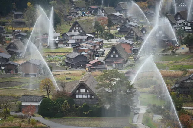 Water is seen discharged over the traditional farm houses at Shirakawa-go, the UNESCO World Heritage site on November 9, 2014 in Shirakawa, Japan. (Photo by Kaz Photography/Getty Images)