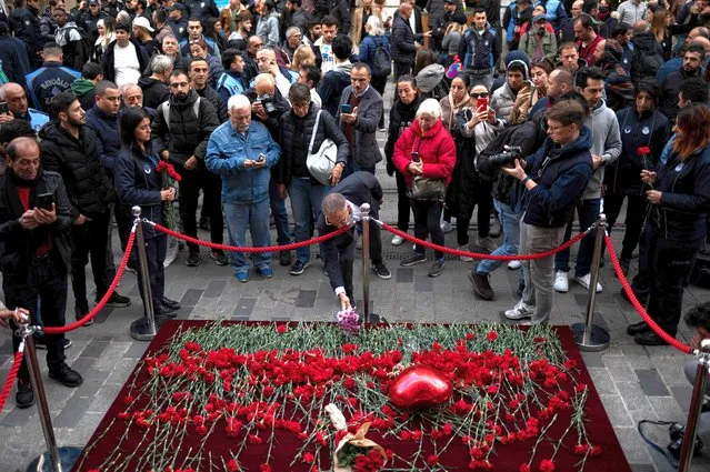 A mourner lays flowers as people grieve the victims of November 13 explosion at the busy shopping street of Istiklal in Istanbul on November 14, 2022. Turkey's interior minister accused the outlawed Kurdistan Workers' Party (PKK) on November 14, of responsibility for a bombing in a busy Istanbul street that killed six people and wounded scores, saying more than 20 people have been arrested. (Photo by Yasin Akgul/AFP Photo)