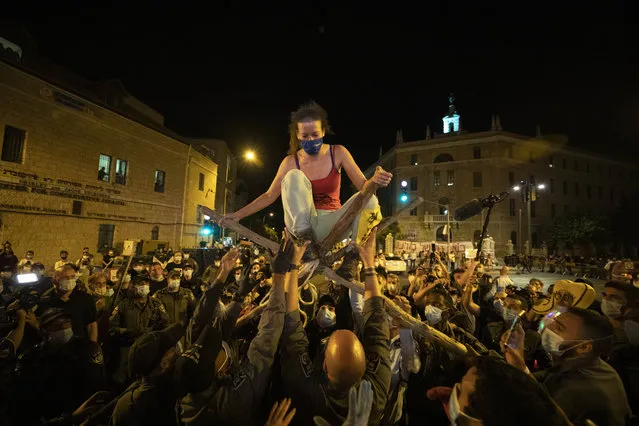 Police officers remove a protester during a demonstration against Prime Minister Benjamin Netanyahu outside his official residence in Jerusalem, Saturday, September 12, 2020, demanding he resign over his trial on corruption charges and what is widely seen as his mishandling of the coronavirus pandemic. (Photo by Sebastian Scheiner/AP Photo)