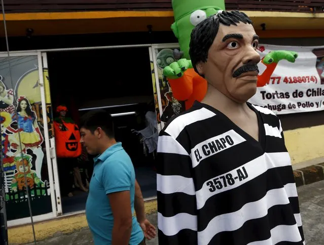A man walks past a Guzman costume on display at the front of a shop, in the Mexican city of Cuernavaca near Mexico City October 14, 2015. (Photo by Henry Romero/Reuters)