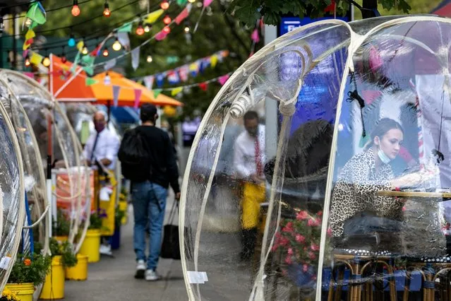 A woman sits outside Cafe Du Soleil under bubble tents following the outbreak of the coronavirus disease (COVID-19) in the Manhattan borough of New York City, New York, U.S., September 23, 2020. (Photo by Jeenah Moon/Reuters)