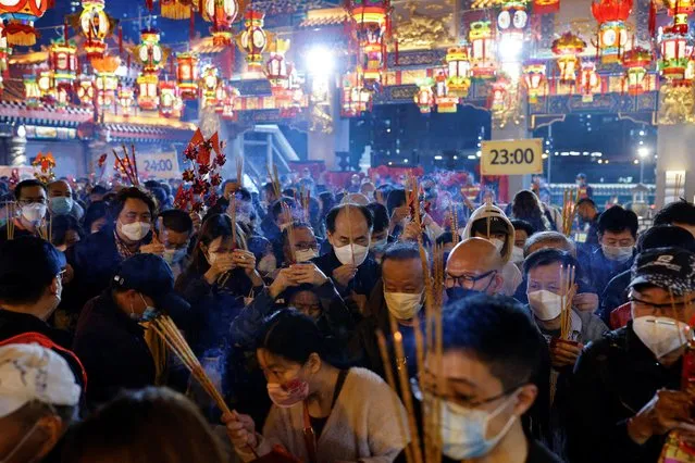Worshippers wearing face masks rush to make their first offerings inside the Wong Tai Sin Temple, a moment before the Lunar New Year, during the coronavirus disease (COVID-19) pandemic in Hong Kong, China on January 21, 2023. (Photo by Tyrone Siu/Reuters)