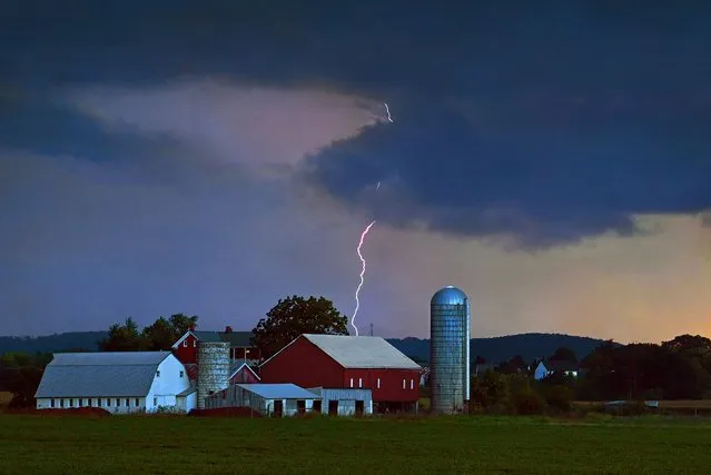 A lightening bolt lands just behind a farm off of Buckeystown Pike at dusk in Adamstown, Maryland on August 09, 2022. Stormy weather hit the area last night and scattered thunderstorms are forecast to occur in and around the DMV area later today. (Photo by Michael S. Williamson/The Washington Post)