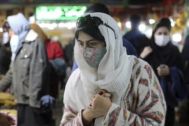 A woman wearing a protective face mask and gloves to help prevent the spread of the coronavirus walks through the Tajrish traditional bazaar in northern Tehran, Iran, Thursday, October 15, 2020. Eight months after the pandemic first stormed Iran, pummeling its already weakened economy and sickening officials at the highest levels of its government, authorities appear just as helpless to prevent its spread. (Photo by Ebrahim Noroozi/AP Photo)