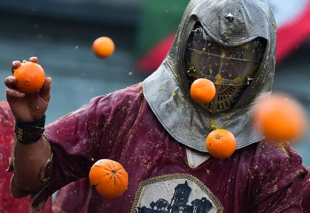 A person participates in the annual “Battle of the Oranges” in the northern city of Ivrea, Italy on February 19, 2023. (Photo by Massimo Pinca/Reuters)