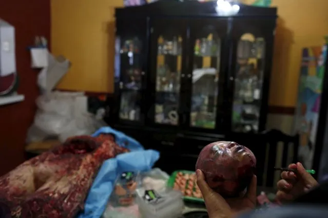 A woman works on the details of a bloody zombie baby head made of gummy candy at the Zombie Gourmet homemade candy manufacturer on the outskirts of Mexico City October 30, 2015. (Photo by Carlos Jasso/Reuters)