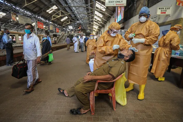 Commuters undergo COVID-19 swab tests at the fort main railway station amid of the coronavirus pandemic in Colombo, Sri Lanka, 12 October 2020. Sri Lankan government implement a curfew in some parts of the country due to a sudden spike of the Covid-19 cluster from a textiles factory in the Gampaha District. (Photo by Chamila Karunarathne/EPA/EFE)
