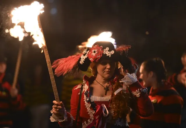 Participants in costume hold burning torches as they take part in one of a series of processions during Bonfire night celebrations in Lewes, southern England, November 5, 2015. (Photo by Toby Melville/Reuters)