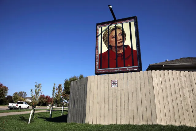 A poster depicting U.S. Democratic presidential candidate Hillary Clinton behind bars hangs in the yard of George Davey in West Des Moines, Iowa, October 11, 2016. Davey said he hung the poster over the weekend wasn't to support Trump, but “because I know a lot of people would like to see Hillary in prison, so I gave them what they want to see”. Davey previously had a portrait of U.S. Republican candidate Donald Trump in the frame. (Photo by Scott Morgan/Reuters)