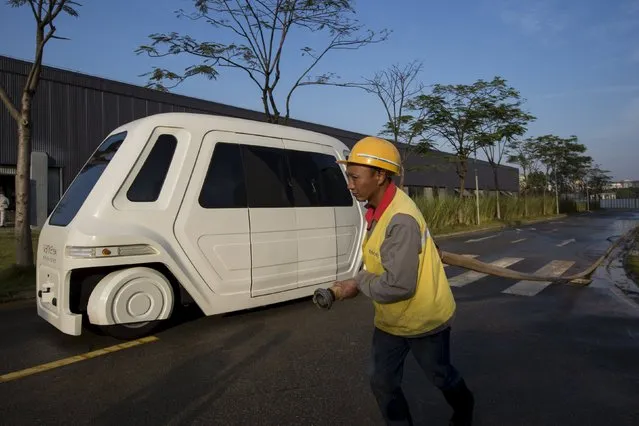 A worker walks past a driverless vehicle at Vanke's Building Research Centre testing area in Dongguan, south China's Guangdong province November 2, 2015. (Photo by Tyrone Siu/Reuters)