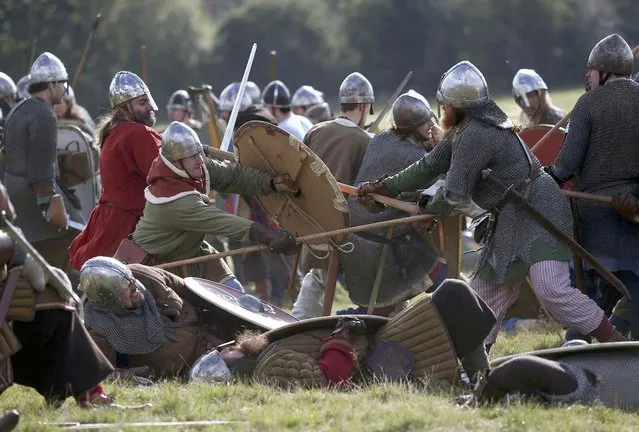 Participants fight during a re-enactment of the the Battle of Hastings on the 950th anniversary of the battle, in Battle, Britain October 15, 2016. (Photo by Neil Hall/Reuters)