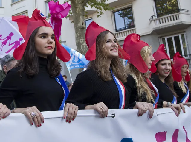 Demonstrators dressed as Marianne, the symbol of the French republic since the 1789 revolution march during a rally to protest gay marriage in Paris, Sunday, October 16, 2016. Thousands of people have marched in Paris to call for the repeal of a law allowing gay marriage, six months before France's next presidential election. (Photo by Michel Euler/AP Photo)