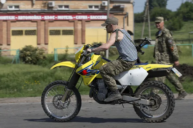 In this Sunday, May 18, 2014 file photo, Donetsk People's Republic platoon commander Arsen Pavlov, also known as Motorola, rides a bike at a checkpoint blocking the major highway which links Kharkiv, outside Slovyansk, eastern Ukraine. Separatist rebels in eastern Ukraine say a notorious warlord has been killed in a bombing in the rebel stronghold of Donetsk. The separatist mouthpiece Donetsk News Agency said on Sunday, October 16, 2016, Arsen Pavlov was killed in Donetsk when a bomb went off in an elevator in the house he was staying. (Photo by Alexander Zemlianichenko/AP Photo)