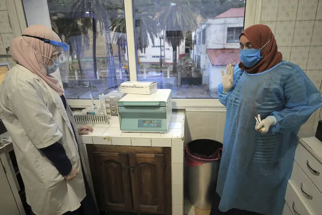 Nurses of a private laboratory work on COVID-19 tests Sunday, December 6, 2020 in Algiers. Algeria received rapid antigen testing kits, adding plans to widen access to the tests across the country by March 2021, and increase the number of private laboratories approved to run PCR tests. (Photo by Fateh Guidoum/AP Photo)